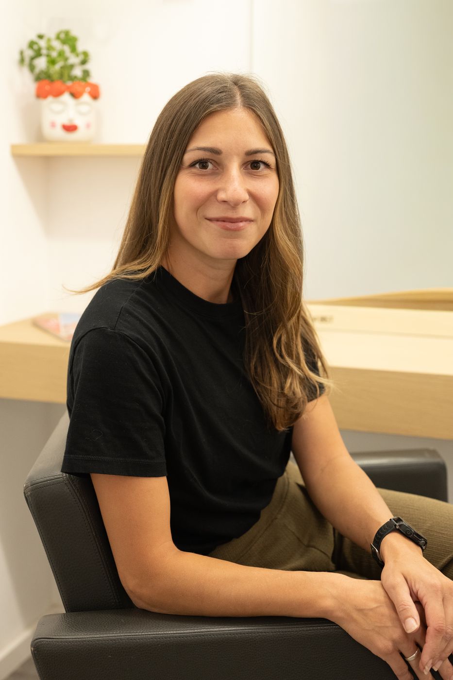 Gisi sitzt lächelnd im Friseurstuhl